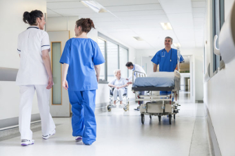 Une personne en train de pousser un brancard dans un couloir d'hôpital