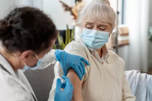 femme medecin vaccinant une senior