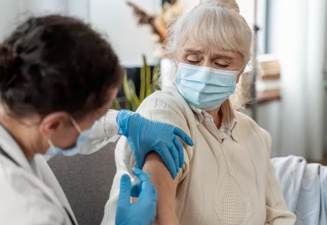 femme medecin vaccinant une senior
